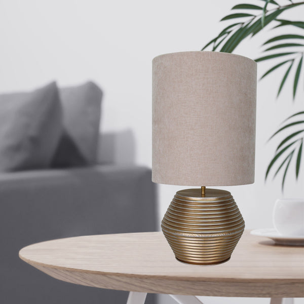Detailaufnahme der modernen Tischleuchte Tin in edlem Gold. Sie bringt einen Hauch von Eleganz in Ihr Zuhause.