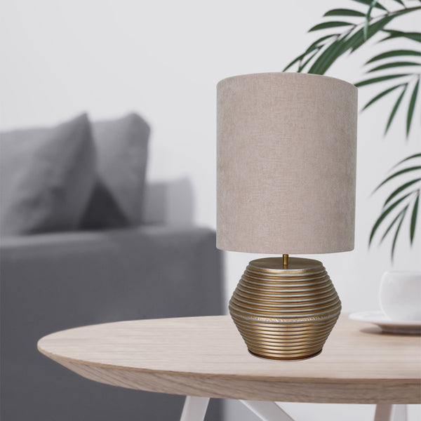 Die goldene Tischleuchte Tin bringt modernen Glamour in Ihr Zuhause. Sie schafft eine warmen, einladende Atmosphäre.