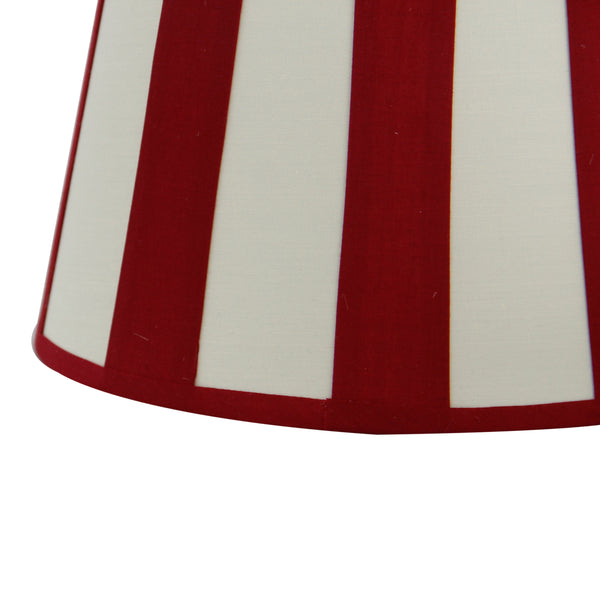 Detailansicht des ovalen Lampenschirms in Rot und Creme. Er verleiht modernen Räumen eine einladende Atmosphäre.