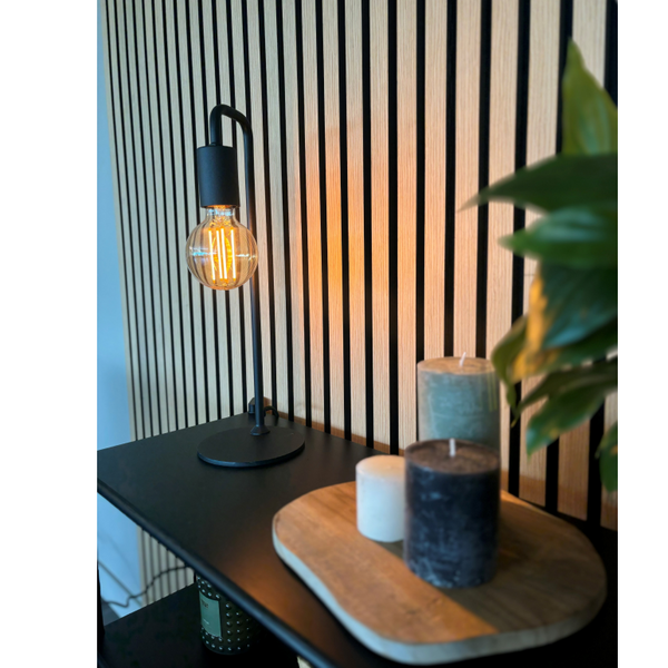 Schwarze Tischleuchte aus der Serie Basic mit industriellem Flair. Sie bringt minimalistisches Licht in moderne Wohnräume.