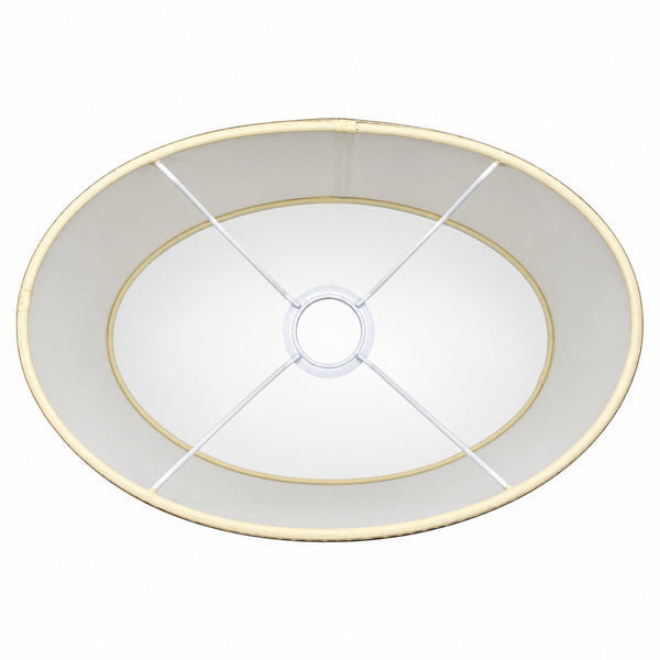 Detailaufnahmen des ovalen Lampenschirms in Creme mit goldenen Akzenten. Er verleiht jedem Raum eine moderne Eleganz.